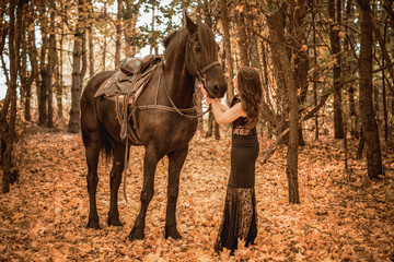 Vintage photo, elegant woman in black dress with a horse