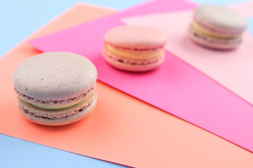 Tasty sweet macaron cakes on color background