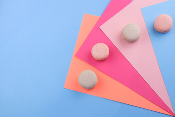 Tasty sweet macaron cakes on color background