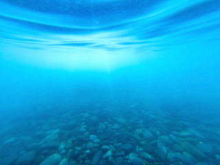 Fototapeta na wymiar Marine underwater background. Sun rays under water.