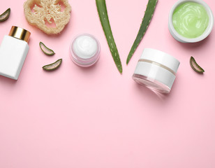 Flat lay composition with aloe vera and cosmetic products on pink background. Space for text