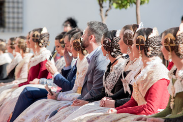 Falleras sitting on a public event in Valencia during the celebration of the Fallas.