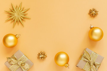 Fototapeta na wymiar Festive background, gold background with glitter gold star and gift boxes and christmas balls, flat lay, top view, copy space