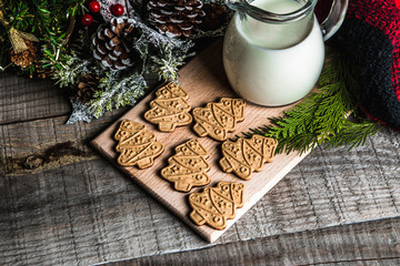 Fresh milk and Christmas cookies with Christmas decorations on a wooden table