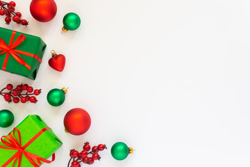 Festive background, gift boxes with red ribbons and a branch of hawthorn, Christmas tree balls and fir twigs on a white background, flat lay, top view, copy space