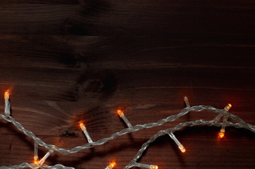 Garland for the Christmas tree on a background of dark wood. Close up, back drop, bokeh.