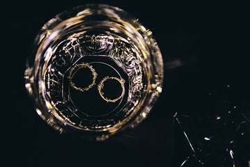 engagement ring in a glass of water a wedding ring in a glass with water on a black background