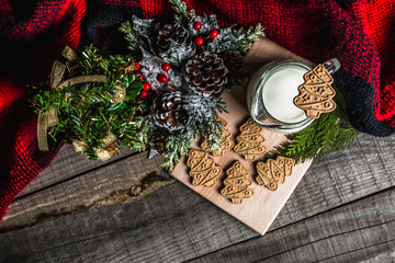 Fresh milk and Christmas cookies with Christmas decorations on a wooden table
