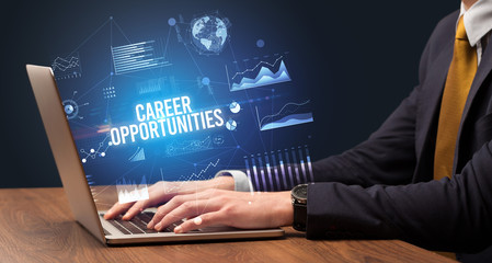 Businessman working on laptop with CAREER OPPORTUNITIES inscription, new business concept