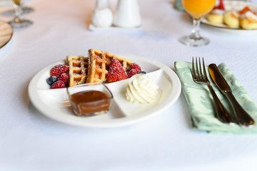 morning Breakfast or brunch in the restaurant. white plate with delicious Viennese waffles. selective focus
