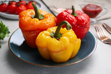 Tasty stuffed bell peppers served on grey table