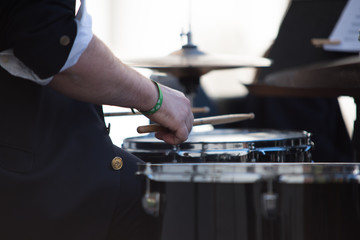 Hands of a musician playing the drums in a concert of classical music in an official act.