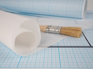 schematic plan of the apartment, drawing on millimeter paper in a roll, near the brush Builder...