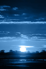 Beautiful blue color sunset over the sun. Amazing summer sunset on the beach. Color of the year 2020. Colorful concept. 