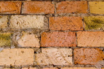 Old brick wall, old texture of red and orange blocks of stone. Closeup