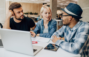 Fototapeta premium Young woman discussing work with diverse colleagues