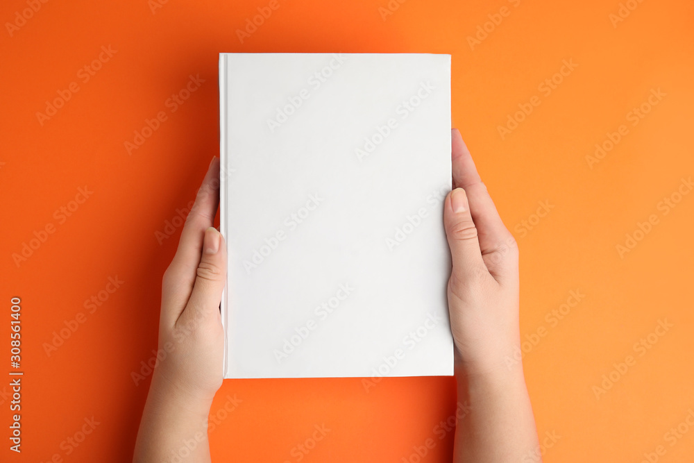 Sticker Woman holding book with blank cover on orange background, top view