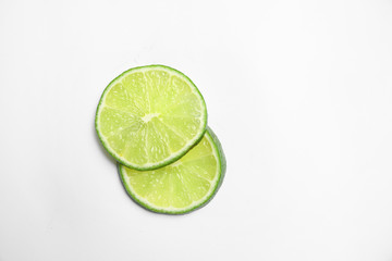 Slices of fresh juicy lime on white background, top view