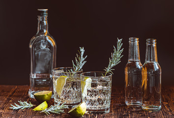 Ideas of winter drinks from gin and tonic for the new year. A bottle of gin and water tonic on a wooden table - 308561835