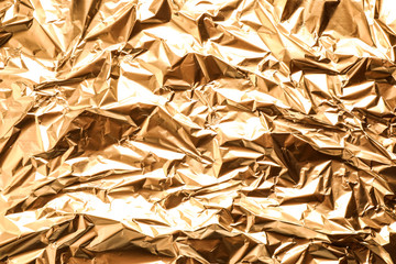 Crumpled gold foil as background, top view
