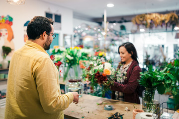 Young woman buying a bouquet of flowers in a florist