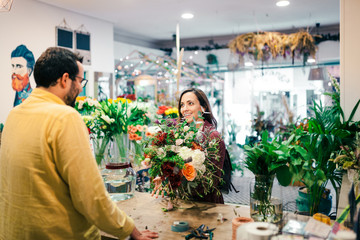 Young woman buying a bouquet of flowers in a florist