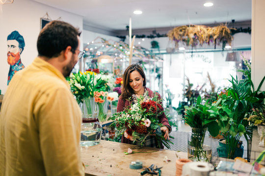 Young woman buying a bouquet of flowers in a florist
