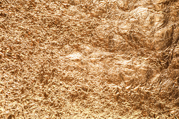 Crumpled gold foil as background, top view