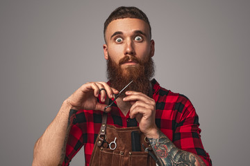Crazy barber cutting ginger beard