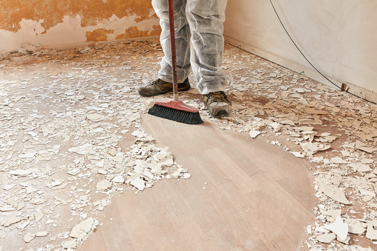 Builder sweeping the floor after renovation