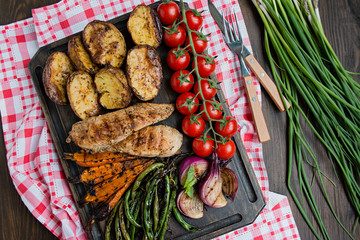 Grilled vegetables on a cutting board on a dark wooden background. Dark wooden background.