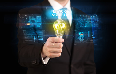 Businessman holding lightbulb with NETWORK SECURITY inscription, online security idea concept