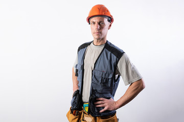 The builder put his hands on his hips. In work clothes and hard hat.