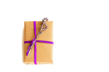 Minimalistic of craft paper and purple thread with lavender flowers gift on an isolated white background.