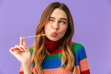 Lovely young girl wearing colorful sweater eating chewing gum