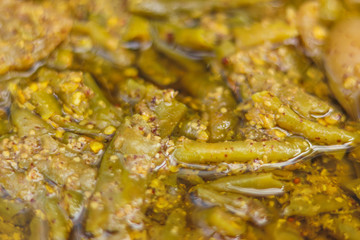 Obraz na płótnie Canvas Spicy Hot Tangy Green Chilli Ginger Garlic Pickles Soaked in Oil Close-Up Indian Mirchi Ka Aachar