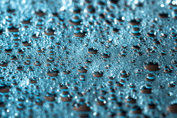 Shiny drops of water on a blue background, abstract rainy wallpaper