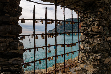 Candados del amor en una reja de hierro en una antigua ventana de piedra en Cinque Terre, Norte de Italia, Liguria.