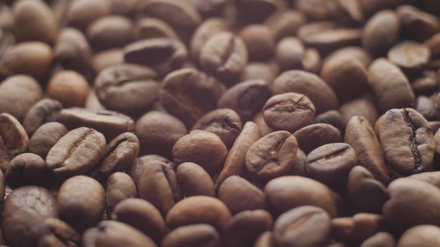 Macro of Roasted coffee beans, can be used as a background and texture. Coffee beans on the table background texture. Background full of coffe beans studio shoot.