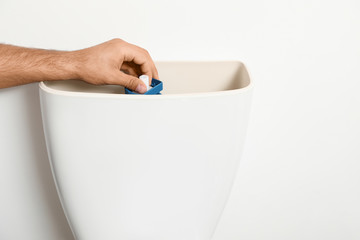 Professional plumber working with toilet bowl in bathroom, closeup