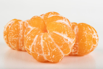 Tasty ripe mandarin on a white table. Peeled citruses.