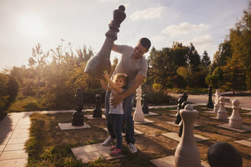 Family having fun near giant chess piece.