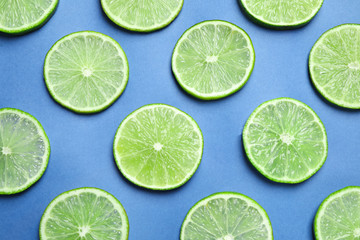 Juicy fresh lime slices on blue background, flat lay