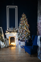 Decorated for The new year Interior of the house. Christmas tree and decorated Studio, garlands of lights, decorations, gift boxes in a cozy home, a large armchair and a fireplace.