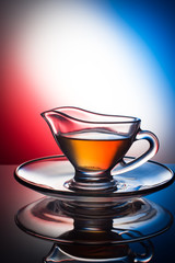 glass cups with a pattern, with fragrant tea on a colored background