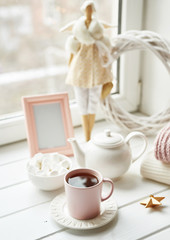 Handmade doll with tea set and marshmallows near window. Cozy winter morning breakfast. Christmas concept and mood. Postcard Template