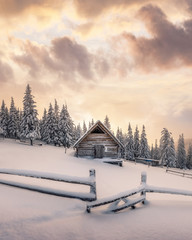 Fantastic winter landscape with wooden house in snowy mountains. Christmas holiday concept. Carpathians mountain, Ukraine, Europe