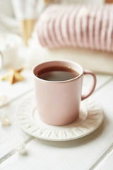 Christmas decor, balls, woolen plaid on the window background, home comfort concept, seasonal winter celebrations. Postcard Template. Christmas pink cup