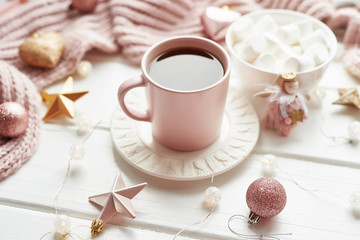 Obraz na płótnie Canvas Christmas decor, balls, woolen plaid on the window background, home comfort concept, seasonal winter celebrations. Postcard Template. Christmas pink cup with marshmallow.
