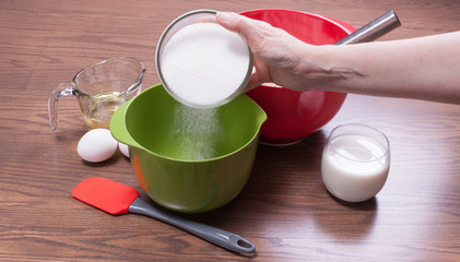 pouring white sugar in a bowl to cook homemade cake